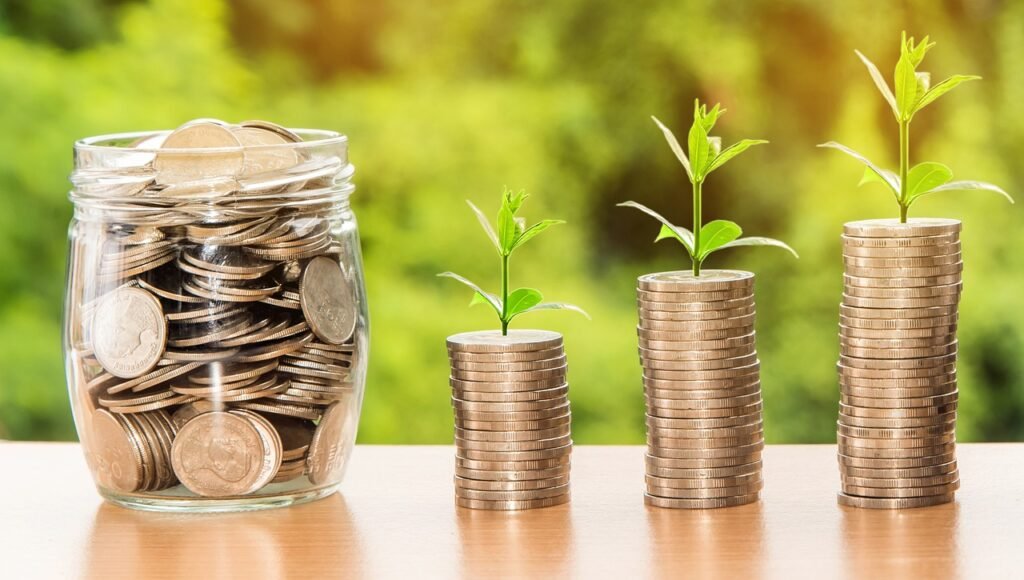 Glass jar filled with coins labeled 'Savings' symbolizing financial success.